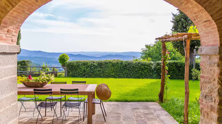 Mesa preparada bajo los arcos, con el jardín al fondo