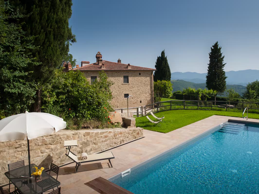 La piscina, con la casa al fondo